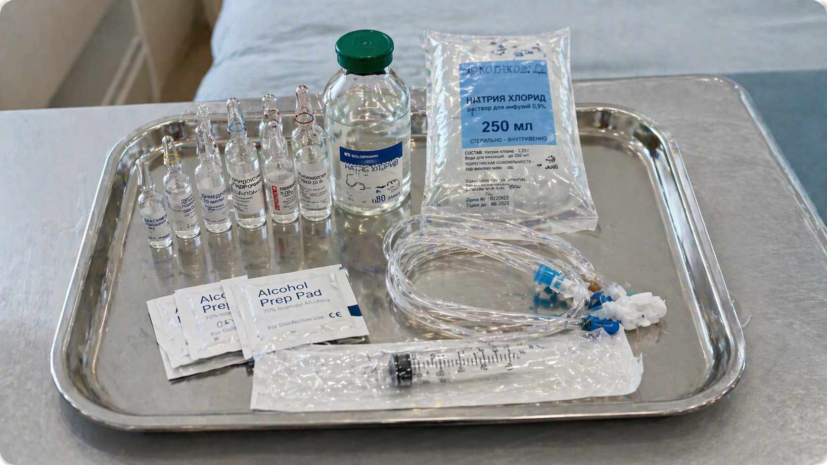 Медицинские препараты, шприцы и система для капельницы на стерильном столике